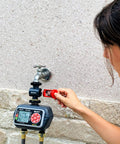Person installing inline water filter for garden hoses and tools anti rust stainless steel 50 mesh screen high flow 11 GPM.