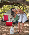 Woman using High Pressure 5L Portable Shower Kit Hand Pump 45 PSI No Power Needed for Camping, rinsing hair outdoors