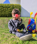 Child playing with Toddler Golf Set with Upgraded Clubs And Shoulder Strap Carrier For Indoor Outdoor Play on grass
