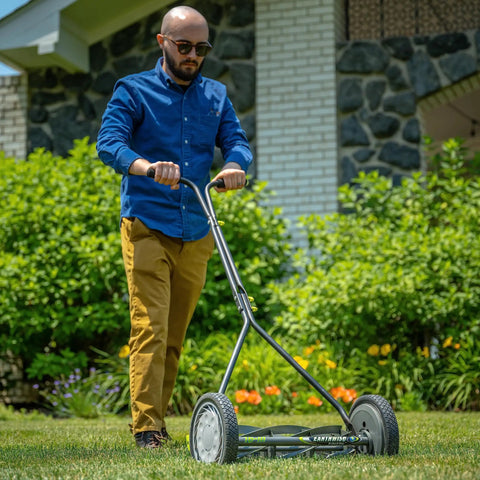 Man using 16-Inch 7-Blade Push Reel Lawn Mower With Ball Bearing Reel And 10-Inch Composite Wheels in garden
