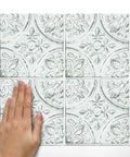 Hand placing White Tin Peel And Stick Tile Backsplash Kit With Self Adhesive Tiles, 4 Pack Of 10.5 Inch Squares, No Grout Needed