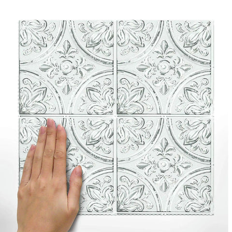 Hand placing White Tin Peel And Stick Tile Backsplash Kit With Self Adhesive Tiles, 4 Pack Of 10.5 Inch Squares, No Grout Needed