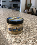 Real Deal Food Grade Beeswax Wood Polish And Cutting Board Wax, Nine Oz Jar on a polished granite countertop.