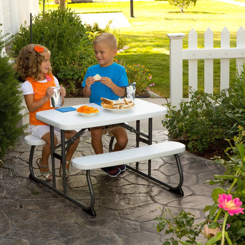 Kids enjoying snacks at Kids Picnic Table With One Hand Adjustable Squeeze Button Setup Folds Flat For Easy Transport.