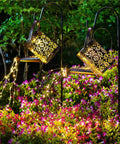 2 Pack Solar Waterfall Watering Can Lights For Garden illuminating flowers with LED copper strands at night.
