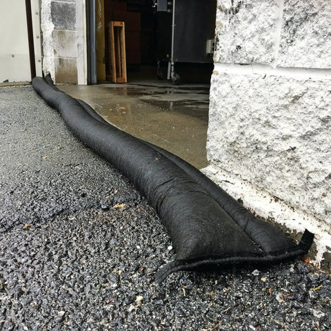 Water Barrier System For Flood Protection Sandless Sandbags 2 Pack 10 Feet Long And 6.5 Inches Wide 0.25 Inches Thick Water Activated Diverter placed on wet driveway