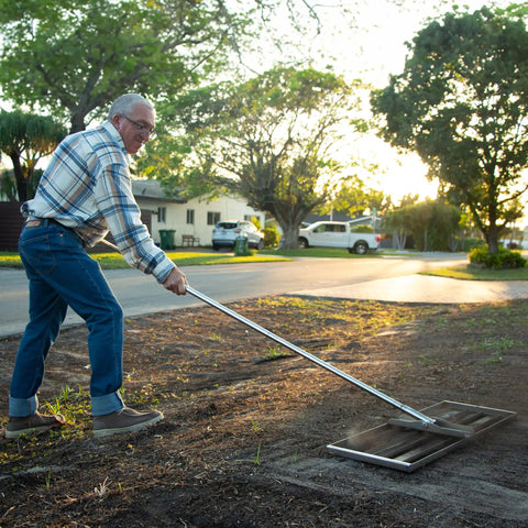 Man using Stainless Steel 30 Inch Lawn Level Rake Pro Grade Yard Tool For Even Grass And Smooth Soil Leveling in garden