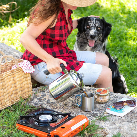 Person using Stainless Steel Coffee Percolator For Stovetop 37oz 2 To 8 Cup Pot With Cool Touch Handle at campsite