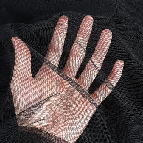 Close-up of a hand behind black polyester hexagonal mesh, showcasing Dope Black Hexagonal Mesh Mosquito Netting For Balcony And Patio.