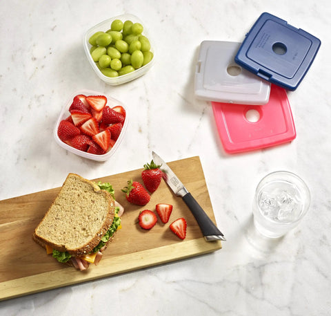 Sandwich, sliced strawberries, and grapes with Slim Reusable Ice Packs For Lunch Bags And Coolers Set Of 4 Multicolor nearby
