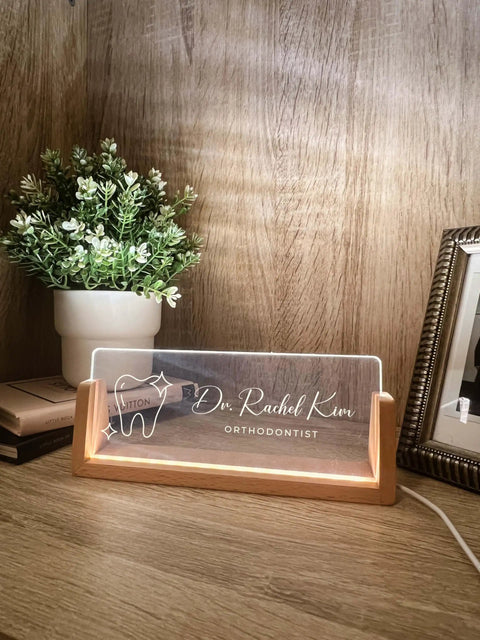 Custom Name And Title Desk Name Plate With LED Light Wood Holder For Dentist Doctor Hygienist Nurse Front Desk Sign Plaque Custom Engraving For Office Decor And Pro Gift shown with engraving and lit base.