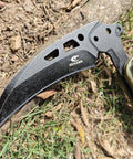 Close-up of Folding Sickle Knife With Sheath For Tactical Survival And Outdoor Pruning Tools on ground, blade detail