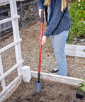 Gardener using Extendable Garden Trowel With Adjustable Telescoping Handle for raised beds, showing ergonomic grip and steel blade