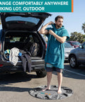 Man using Wetsuit Changing Mat And Dry Bag For Surfing And Kayaking All In One 30 Inch Leakproof Gear Mat in parking lot