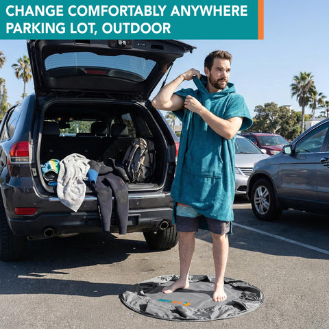Man using Wetsuit Changing Mat And Dry Bag For Surfing And Kayaking All In One 30 Inch Leakproof Gear Mat in parking lot