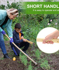 Person using Heavy Duty Curved Garden Hoe Workhorse 15 Inch Stainless Steel Mattock With Wooden Handle for gardening in backyard.