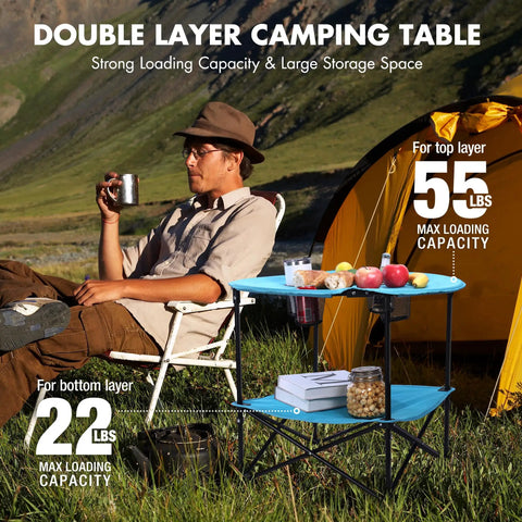 Folding Camping Table Lightweight Double Layer Round Table With 4 Cup Holders And Carry Bag Portable Beach Table For Camping Travel Fishing And Outdoor Activities Blue displayed in use at a campsite near a yellow tent with a person seated holding a cup.