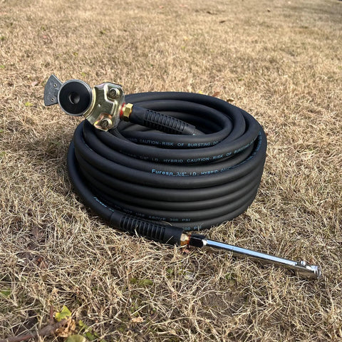 Heavy Duty Truck Tire Inflator Kit With 3/8 By 50 Ft Hybrid Air Hose, Glad Hand Connector And Air Chuck coiled on dry grass.