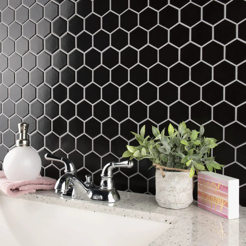 2-Inch Hex Matte Black Porcelain Mosaic Tile For Floors And Walls Mesh Mounted 11.13 x 12.63 Inches near a faucet and plant