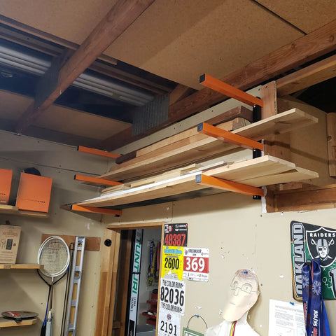 Beefy Heavy Duty Lumber Storage Rack Wall Mount Metal Organizer 3 Level Wood Storage System in a garage holding wood planks