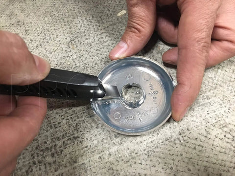 Person cutting Split Chrome Plastic Escutcheon Cover Plate For 1/2 Inch CTS Copper Pipe And PEX 5/8 Inch OD with a utility knife.