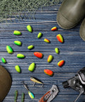 60 Piece Foam Floats Set For Fishing, Bullet Shaped Floats For Snell Rigs displayed on blue wood background with fishing gear