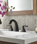 Selia 8 Inch Widespread Bathroom Sink Faucet Two Handle 3 Hole Deck Mount In Tuscan Bronze Finish next to a flower vase