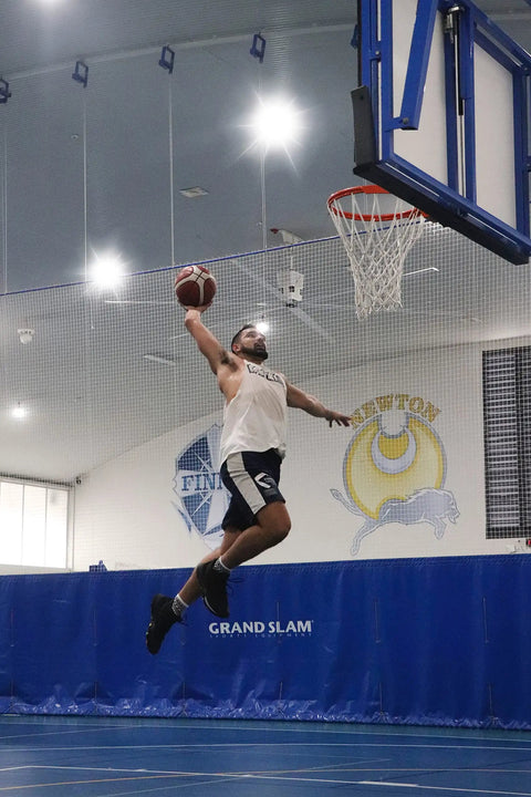 Basketball player leaping towards hoop in indoor court under bright lighting, showcasing 400W LED Stadium Flood Lights Outdoor Beast Mode Bright 56000 Lumens 6500K Daylight IP67 Waterproof 6KV Surge Adjustable Angle Heavy Duty Exterior Flood Lighting For Sports Fields Arenas