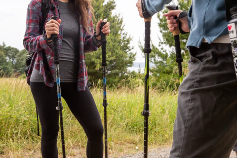 Hikers using Lightweight Carbon Fiber Trekking Poles Set Of 2 With Quick Adjustable Locks For Hiking And Walking Blue outdoors.