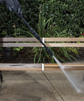 Powerful 12 Amp Electric Pressure Washer With Adjustable Spray Wand For Home Cleaning Of Driveways Patios Decks Cars Boats RVs And More A Versatile Outdoor Washing Solution used on a wooden bench