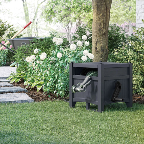 Hose Hideaway Storage Reel Box in Cyberspace Grey next to garden, holds 100 ft of 5/8 in vinyl hose, no assembly required.