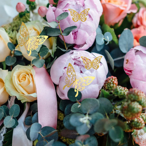 180 Pcs 3D Butterfly Wall Decor Kit in gold on floral arrangement with peonies and roses, perfect for weddings and parties.