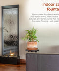Mirror Waterfall Fountain With Stones And Lights for indoor zen decor in living room, 72 inches tall, water feature with plants nearby.