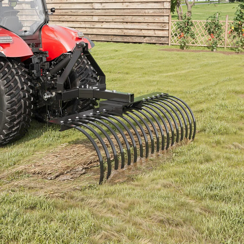 Tow Behind Dethatcher 50 Inch Wide With 18 Steel Tines attached to a tractor, leveling and aerating lawn grass.