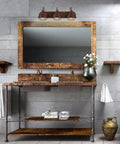Three Light Modern Industrial Farmhouse Vanity Light in Brushed Bronze Finish above rustic bathroom mirror with bronze frame