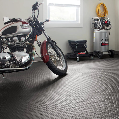 Motorcycle parked on Interlocking Rubber Floor Tiles 18x18 Inch Diamond Plate Squares That Are Tough-As-Nails For Home Gym Garage Basement And Trade Show Floors, Durable Puncture-Resistant Mats, 24 Pack Black in garage.