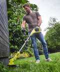 Pro Grade 18 Volt Cordless Grass Trimmer With Dual 2.0 Ah Batteries And Telescopic Handle in action on grass.