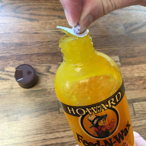 Hand opening 16 oz bottle of Beeswax Wood Polish And Conditioner For Furniture Feed-N-Wax with carnauba wax and conditioning oils.