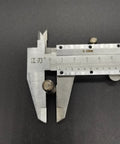Front view of a steel vernier caliper measuring a small cylindrical metal pin.