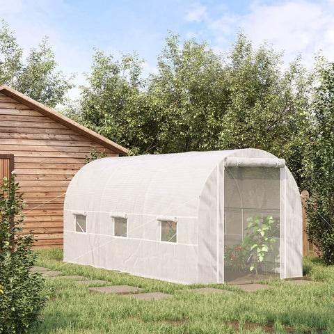 Walk In Tunnel Greenhouse Kit For Serious Gardeners With Large 14.6 By 6.6 By 6.6 Feet White Steel Frame Clear Plastic Cover 6 Roll Up Windows And Door Easy Setup Garden Hot House To Extend Your Growing Season in a backyard next to a wooden structure, with greenery inside.