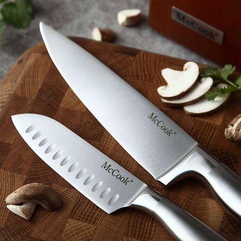 Close-up of two German Stainless Steel Kitchen Knives on a wooden board, showcasing the sharp blades and stainless steel handles.