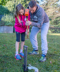 Father and daughter setting up Outdoor Slackline Starter Kit With Two Frame Stands Three Height Settings From 12 to 20 Inches.