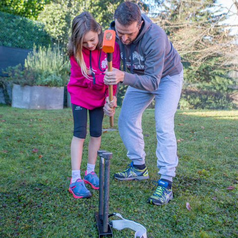 Father and daughter setting up Outdoor Slackline Starter Kit With Two Frame Stands Three Height Settings From 12 to 20 Inches.