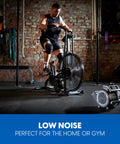 High Power Floor Fan With Remote Control 32 MPH Air Mover for home gym use, next to exercise bike in brick-walled gym