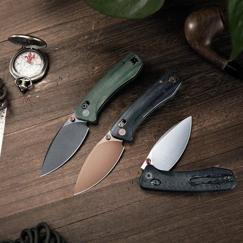 Three Koala Plus-BM Folding Knives with 2.99 inch blades, 14C28N stainless steel, black and green micarta handles, on a wooden surface.