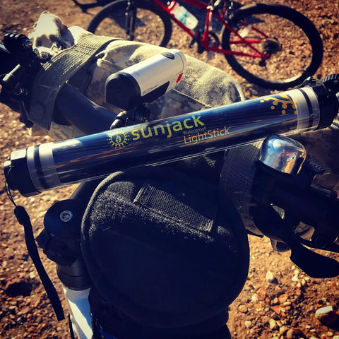 Waterproof Rechargeable LED Flashlight And Power Bank For Camping And Outdoor Adventures mounted on a bicycle handlebar.