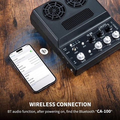 Portable 20W Rechargeable Guitar Amp With Distortion And Delay Effects, Bluetooth Ready, shown with smartphone, desktop setting