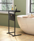 C Shaped End Table For Small Spaces With Storage Bag, black narrow table beside a bathtub with toiletries.