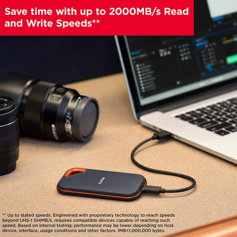 1TB Extreme Pro Portable SSD with USB-C connected to a laptop, showcasing its compact and rugged design, next to a camera lens.
