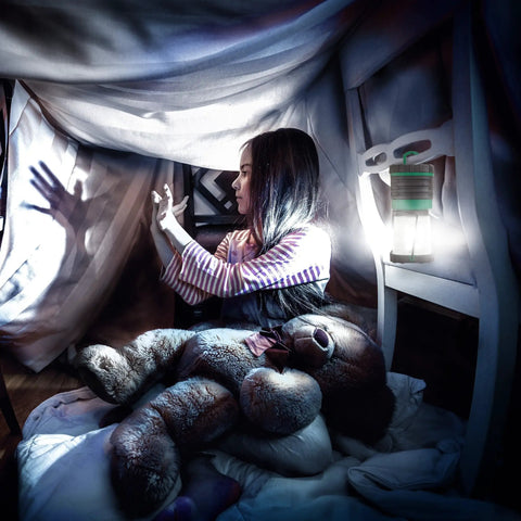 Child in indoor fort making shadow puppets with Ultra Bright Camping Lantern With 500 Lumens Battery Powered Light That Slaps Waterproof Portable And Lightweight For Camping Power Outages Hurricanes Emergency Prep And Outdoor Adventures on chair.